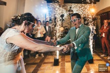 Bride and groom at Le Clos des Passerelles start first dance, surrounded by sparklers, wearing sunglasses, celebrating joyfully.