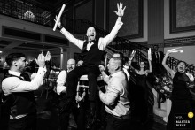 At Vault 634, a groom is joyfully lifted in a chair during the reception. The award-winning black-and-white photograph highlights the photographer's skill at documenting the vibrant energy and celebration of a wedding.