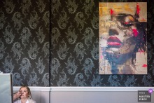 Bride Has Makeup Applied At Landgoed Wolfslaar Breda Netherlands With Striking Painting Creating Visual Contrast At Landgoed Wolfslaar in Breda, Netherlands, a bride has her makeup applied for her wedding. The minimalist shot is made richer by a large painting of a woman with heavy makeup on the wall, creating a striking visual contrast.
