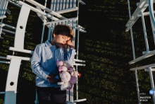 In Meuse, at the reception hall during cocktail hour, a little boy who caught the wedding bouquet rests quietly on a row of chairs. The winning photograph highlights the photographer's skill at capturing genuine, unscripted moments.