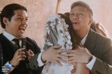 Excited friends hug at a Domaine de Sainte Claire, France wedding, with one friend filming the moment