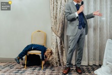 Child Lays Bored During Father of the Bride Speech at Nottinghamshire Golf Club Child, laying on belly over a chair, disinterested in Father of the Bride's speech at the Nottinghamshire Golf Club, Nottingham, UK.