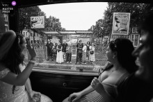 Black and white photo of a bride waving from an Amsterdam tram.