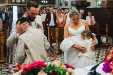French couple hugging their children during church wedding in Moselle.