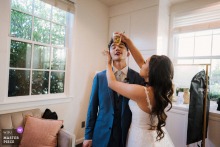 At Cuvier Club in La Jolla, California, the photographer captures the bride pressing a cold drink to the groom’s forehead after he overheats, expertly freezing a tender, humorous, and caring post-ceremony moment.