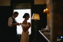 Kettner's Townhouse, London: The groom helps the bride remove confetti from her dress.