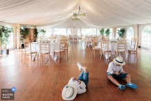 Versailles reception hall, before dinner: Two children engrossed in their phones, a modern contrast to the grand, empty room.