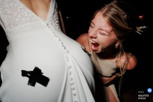At Château de Pruzilly, the photographer captures a wild, playful moment as the bridesmaid bites the bride’s buttocks, expertly showcasing silly party antics and the uninhibited fun of close friends.