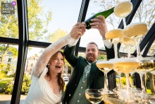 At Hotel Flora Batava in Nieuwersluis, the photographer captures the bride and groom joyfully pouring a champagne tower during their reception, highlighting genuine happiness and impeccable moment-capturing skill.