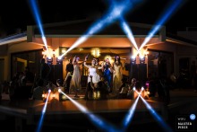At Divan Kuruçeşme, Istanbul, the photographer captures the bride dancing onstage with friends under dramatic DJ lights that illuminate the night sky, skillfully showcasing vibrant celebration and dynamic energy.