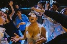 At Divan Kuruçeşme, Istanbul, the photographer skillfully captures a playful, high-angle moment as the groom’s father places money on the bride’s head, highlighting dynamic party energy and vibrant dance floor fun.