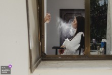 At Divan Kuruçeşme in Istanbul, the photographer skillfully captures the precise moment a makeup artist sprays the bride's face, highlighting both anticipation and elegant detail in this intimate getting-ready shot.