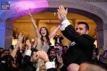 At a Lisbon reception, the bride and groom ride above everyone’s heads as they open the dance floor. The photographer’s technical mastery captures this epic, exhilarating start to the celebration.
