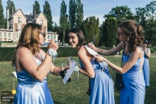 At Chateau de Quesmy, witnesses play a game outside, using a bridesmaid’s back as a writing desk. The photographer’s creative timing highlights the spontaneous fun and camaraderie of the wedding celebration.