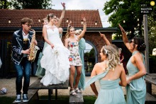 At Froginwell Vineyard, a saxophonist dances on a table with the bridal party. The photographer’s creative timing captures the exuberant, music-filled celebration and lively energy of the women at the wedding.