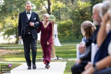 At Georgia Palms in Powder Springs, Georgia, the mother of the bride reacts with emotion and warmth to guests as she walks down the aisle to the ceremony.