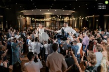 Every Guest Joins A Lively Hora Dance On The Crowded Floor At OSRUI In Oconomowoc Wisconsin At OSRUI in Oconomowoc, Wisconsin, the dance floor overflows as every guest joins the couple for a lively Hora Dance, with a dynamic wide view capturing the festivities.