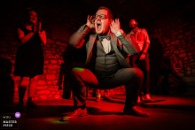 At Weingut Hahn in Alzey, a male guest dances energetically and squats under red party lights, bringing excitement and fun to the celebration.