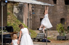 At Fort Honswijk during the reception, bridesmaids are caught in a candid moment of boredom, offering a humorous contrast to the wedding festivities and highlighting the unscripted side of celebration.