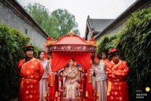 Bride Waves From Bridal Sedan At Aman Summer Palace Hotel Beijing At Aman Summer Palace Hotel in Beijing, the bride waves and greets her friends from inside her traditional bridal sedan, capturing a joyful and heartfelt moment steeped in wedding tradition.