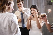 On the lively dance floor at Pagu restaurant in Cambridge, Massachusetts, the bride joyfully shows off her wedding ring, surrounded by friends in the indoor venue atmosphere.
