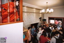   From her home in Nanping, Fujian, the bride peers through the railing, watching guests play lighthearted games in the attic as she awaits the next part of the ceremony.