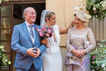 Bride Gently Wipes Away Tear From Mother’s Face Before Ceremony In Martos, Jaén, Spain, Sharing Tender Connection Just before the ceremony in Martos, Jaén, Spain, the bride gently wipes away a tear from her mother’s face, revealing a touching moment of connection and role reversal.