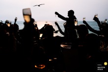   During emotional wedding speeches at Tunnels Beaches in Ilfracombe, England, a silhouetted guest stands out against the light, their figure quietly capturing the mood of the moment.