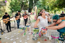   A lively moment at Vauvert, France, has the bride enjoying a celebratory drink, surrounded by guests and the joyful buzz of the reception's live outdoor music.