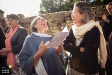 Outside Eglise Saint-Martin in Digoin, France, laughter erupts among guests, illuminated by the warm glow of the sunset after the church ceremony.