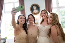 Moments before the ceremony at Chateau de Bourneau, Vendée, the bride and her bridesmaids gather for a cheerful selfie, capturing their excitement and anticipation.