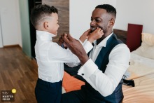  A father and son share a quiet, intimate moment during wedding preparations in Luzern, Switzerland, with an atmosphere of gentle connection and tenderness between them.
