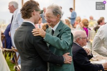   At a private residence in Newport, Vermont, the groom and a family member share a heartfelt, emotional exchange during the wedding reception surrounded by loved ones.