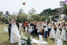 In Wedding Scene in Poyang County, Shangrao City, Jiangxi Province, the bride and groom toss their bouquet together, and the air seems to brighten with shared, playful release.
