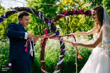 The ceremony location in London holds the bride and groom as they tie the knot with solemn concentration.