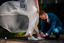In Delft, the Netherlands, the groom helps his bride with her shoes, turning a practical gesture into a small act of care before the day moves forward.