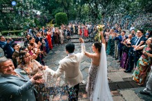 The church exit in Mexico City sends the couple into daylight, and the scene feels brisk and ceremonial, with motion, relief, and city energy all pulled together.