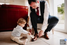 In Saint Genis Laval, the little girl helps her father put on his shoes, a small domestic ritual that turns wedding preparation into something playful and touching.