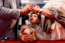 At Mairie de Tavernay, the groom's grandson watches the ring exchange with steady concentration, his small face adding wonder and quiet gravity to the ceremony.