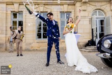At Chateau d'Arcelot, the couple opens champagne at cocktail hour, and the first burst of foam feels like the day’s own applause, bright and irreverent.