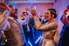 At Kanuhof Zur Ems in Lingen, Emsland, Germany, the bride and groom have fun with the guests on the dance floor, where the night finally drops its formal mask.