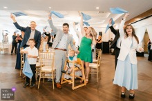 At Vellano Estate in Chino Hills, California, wedding guests react to the bride and groom’s arrival during the reception, their faces opening like a single, delighted ripple.