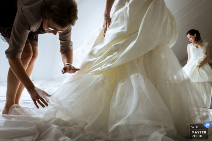 Rotterdam bridesmaid helping bride get her dress ready for the wedding - Zuid Holland wedding photo