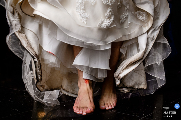 Foto de detalle de los pies de la novia debajo de su vestido de novia por un fotógrafo de bodas de Atlantic, NJ.