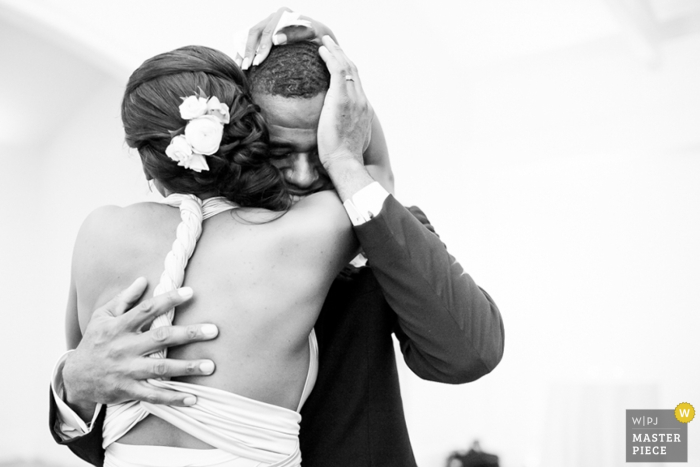 Black and white photo of the bride and groom hugging by a Raleigh, NC wedding photographer.