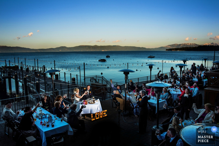 Photo by: <a href="https://www.wpja.com/contests/2016-q4-photography-competition/toastingspeeches/1932826">Jessica Stout - United States</a> The bride and groom are toasted during the reception on a dock in this photo by a Jacksonville, FL wedding photographer.