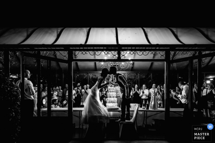 Photo by: <a href="https://www.wpja.com/contests/2016-q4-photography-competition/toastingspeeches/1938976">William Lambelet - France</a> Montpellier wedding photographer captured this black and white photo of the bride and groom kissing under a tent awning