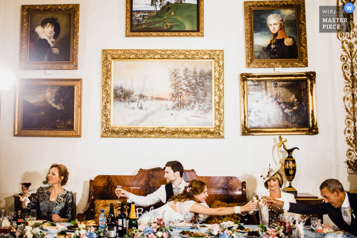 A noiva, o noivo e seus convidados comemoram com vinho e champanhe nesta foto tirada por um fotógrafo de casamento na Rússia.