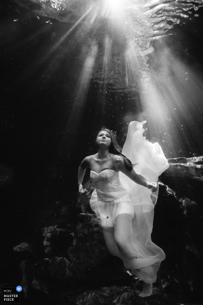 Zwart-witfoto van de bruid in haar trouwjurk onder water door een trouwfotograaf uit Costa Rica.