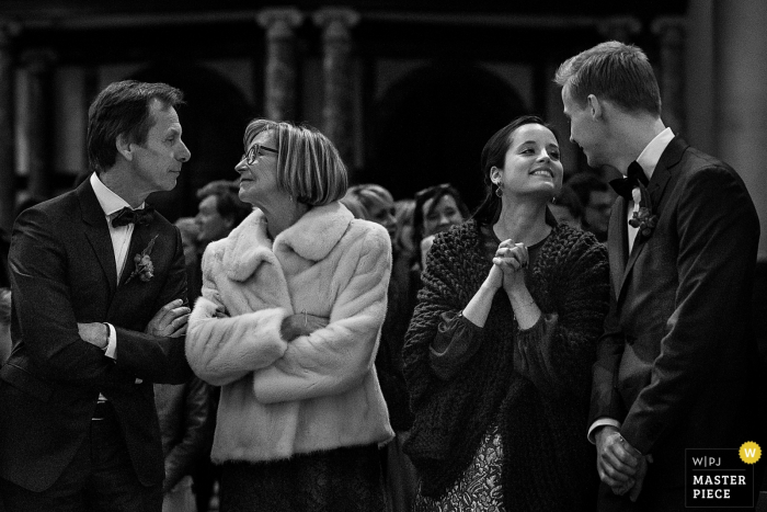 Photo by: <a href="https://www.wpja.com/contests/2016-q4-photography-competition/symmetry/1937401">Joshua Dhondt - Belgium</a> Black and white photo of an older couple and younger couple leaning toward each other by a Flanders wedding photographer.